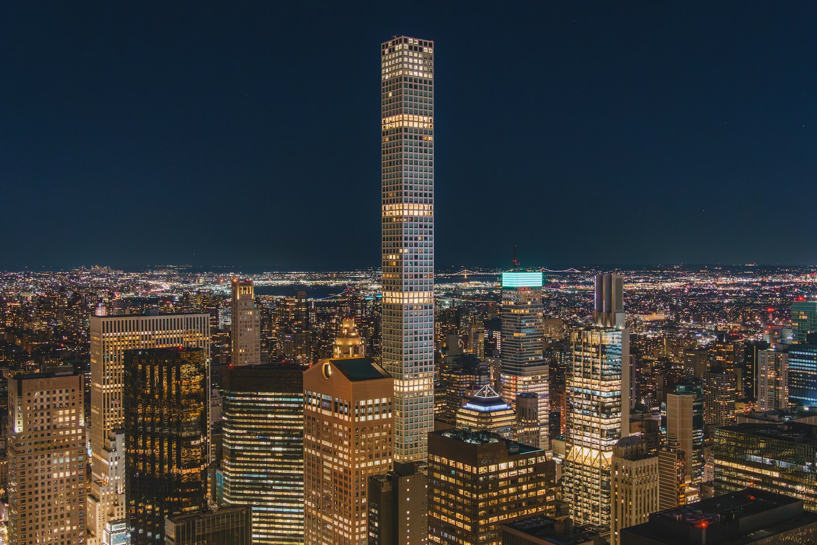 Illuminated Manhattan high rises beneath a dark evening sky.